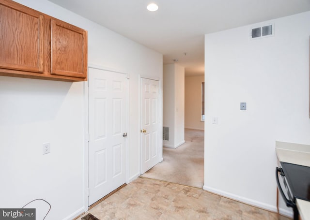 corridor featuring light colored carpet