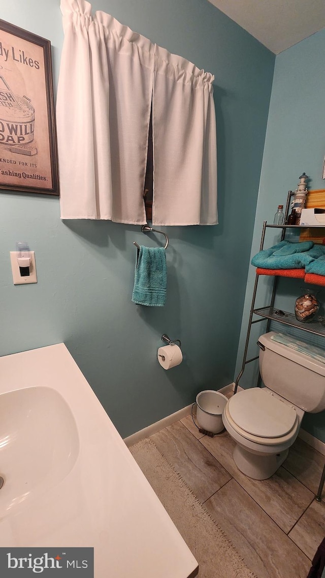 bathroom with sink, hardwood / wood-style floors, and toilet