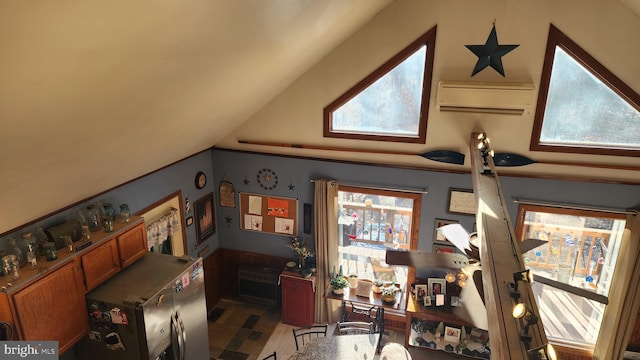 interior space featuring an AC wall unit, a wealth of natural light, tile patterned flooring, and vaulted ceiling