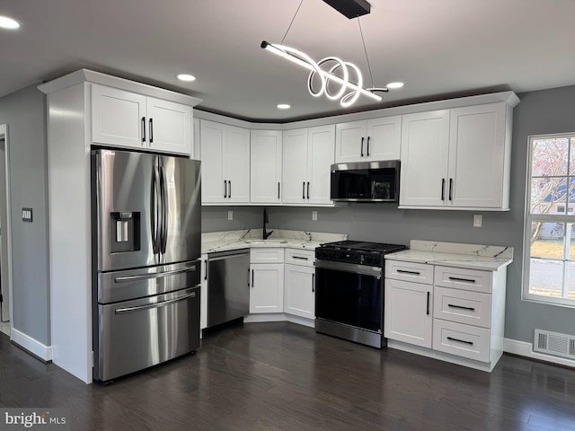 kitchen with white cabinetry, stainless steel appliances, and dark wood-type flooring