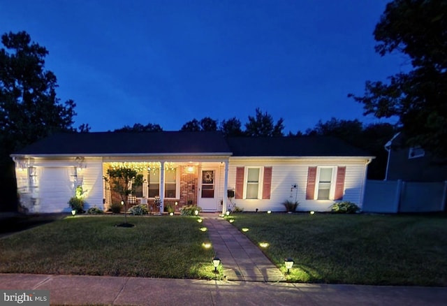 single story home featuring a garage and a yard