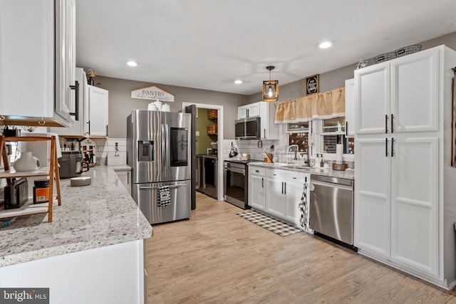 kitchen with white cabinetry, backsplash, pendant lighting, appliances with stainless steel finishes, and light wood-type flooring