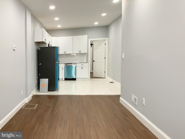 kitchen with white cabinetry, stainless steel appliances, and light wood-type flooring