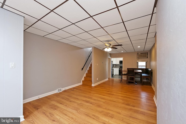 unfurnished living room featuring light wood-type flooring, a drop ceiling, and ceiling fan