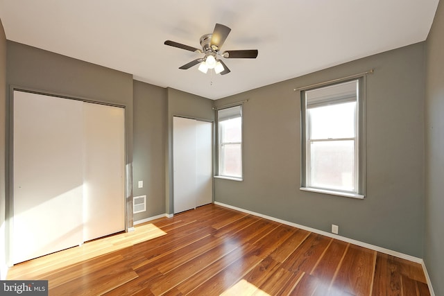 unfurnished bedroom with ceiling fan, a closet, and hardwood / wood-style flooring