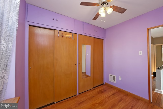 unfurnished bedroom with ceiling fan, multiple closets, and light hardwood / wood-style flooring