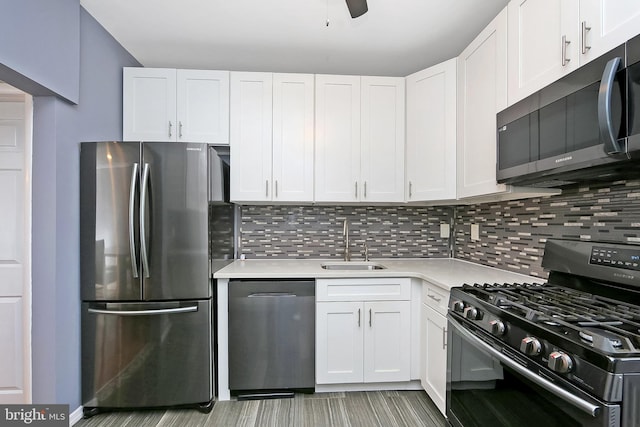 kitchen with backsplash, sink, white cabinetry, and stainless steel appliances