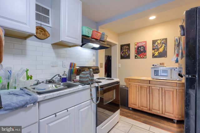 kitchen featuring white appliances, range hood, tasteful backsplash, light hardwood / wood-style floors, and white cabinetry