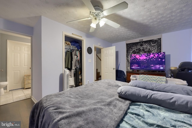 tiled bedroom with ceiling fan, a closet, and a textured ceiling