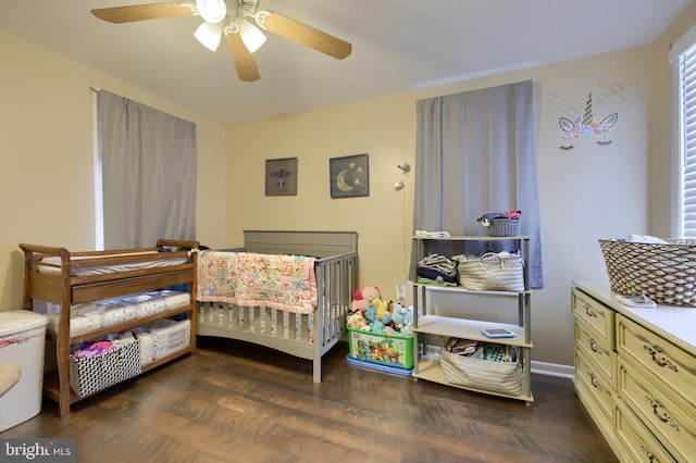 bedroom featuring a crib, electric panel, ceiling fan, and dark wood-type flooring