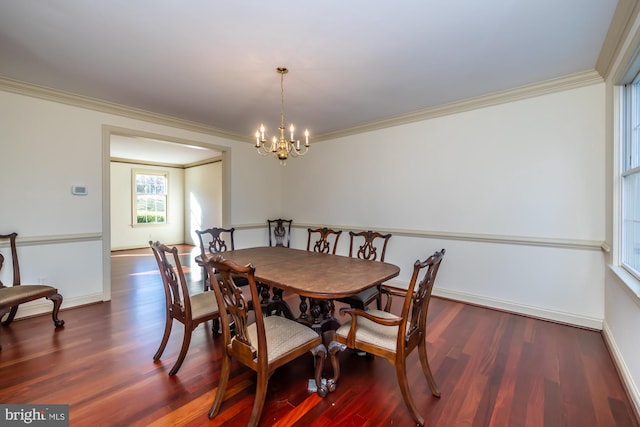 dining area with dark hardwood / wood-style flooring, ornamental molding, and a chandelier