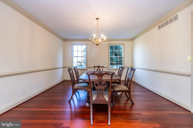 dining area featuring dark hardwood / wood-style flooring, ornamental molding, and an inviting chandelier