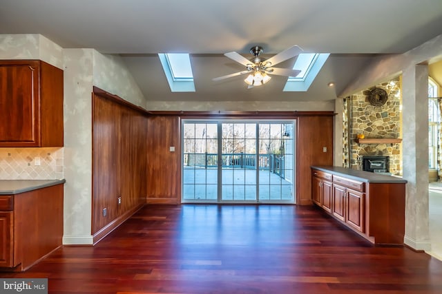 kitchen with dark hardwood / wood-style floors, ceiling fan, lofted ceiling, and a fireplace