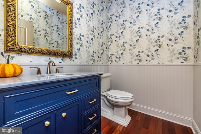 bathroom with toilet, vanity, and hardwood / wood-style flooring