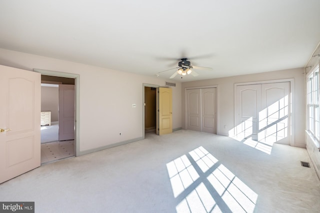 unfurnished bedroom featuring ceiling fan and light colored carpet