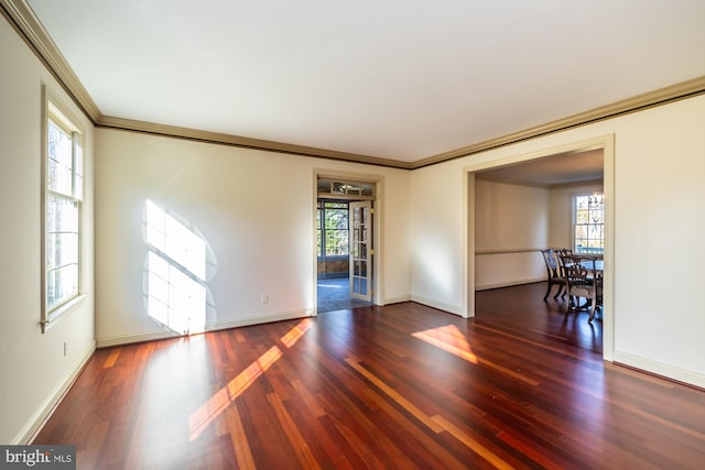 unfurnished room featuring dark hardwood / wood-style floors, a healthy amount of sunlight, and ornamental molding