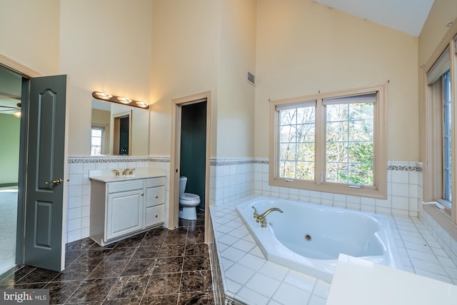 bathroom featuring vanity, toilet, and high vaulted ceiling