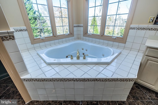 bathroom featuring vanity and a relaxing tiled tub