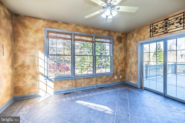 unfurnished room with ceiling fan and plenty of natural light