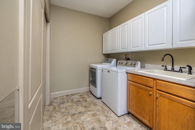 washroom with washer and clothes dryer, sink, and cabinets