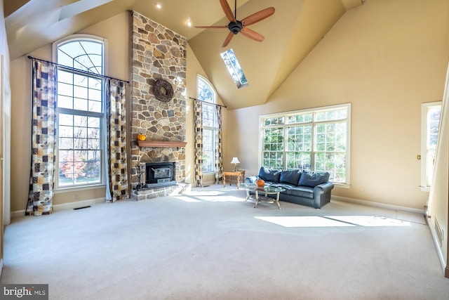 unfurnished living room with a wealth of natural light, high vaulted ceiling, light colored carpet, and ceiling fan