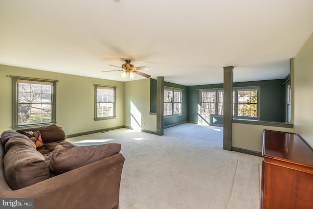 living room with ceiling fan, a healthy amount of sunlight, and light colored carpet