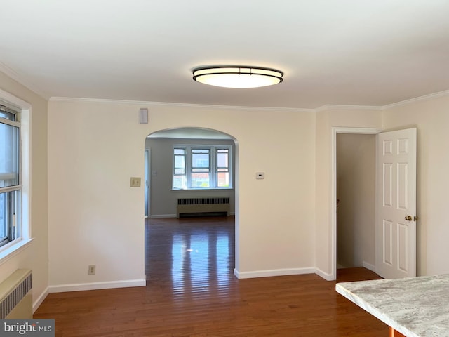 unfurnished room with dark hardwood / wood-style floors, radiator, and ornamental molding