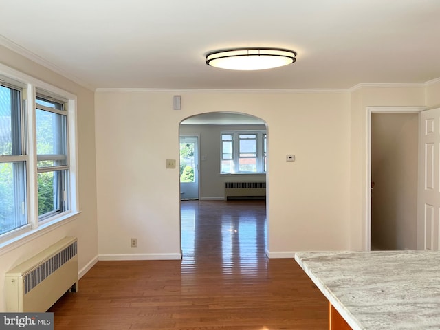 interior space featuring dark hardwood / wood-style floors, radiator, and ornamental molding