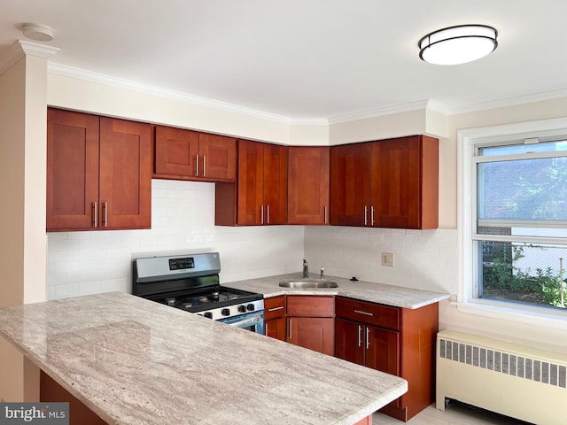 kitchen featuring kitchen peninsula, radiator heating unit, stainless steel gas stove, and sink