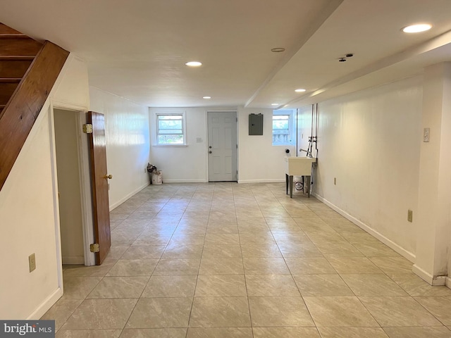 basement with light tile patterned floors and electric panel