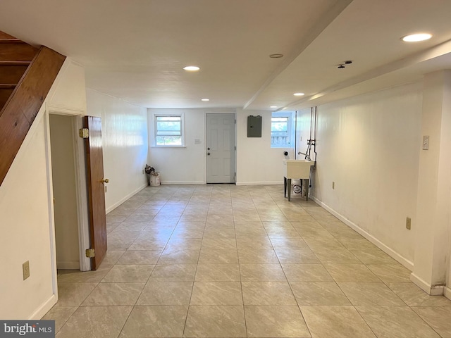 basement with electric panel and light tile patterned flooring