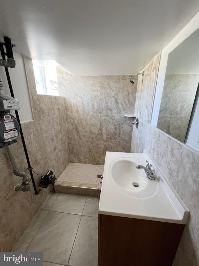 bathroom featuring a shower, tile patterned flooring, vanity, and tile walls