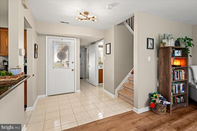 tiled entryway featuring an inviting chandelier