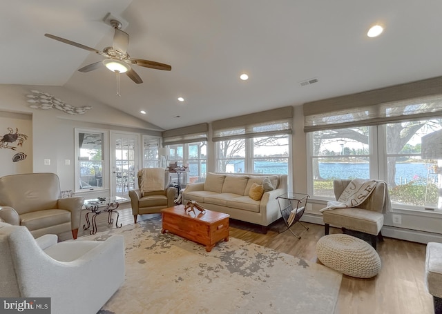 living room featuring ceiling fan, hardwood / wood-style floors, a water view, and vaulted ceiling