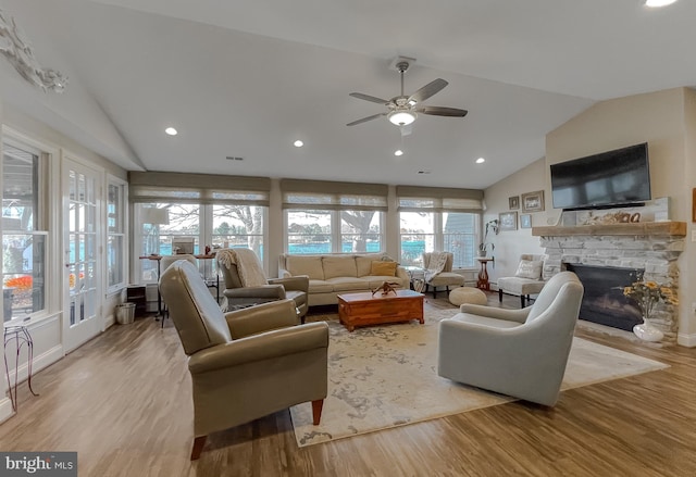 living room featuring ceiling fan, light wood-type flooring, lofted ceiling, and a wealth of natural light