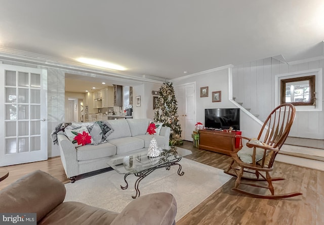 living room featuring crown molding and light hardwood / wood-style floors