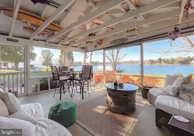 sunroom / solarium featuring a healthy amount of sunlight and a water view