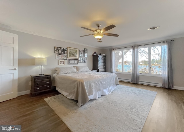 bedroom with ceiling fan, dark hardwood / wood-style flooring, crown molding, and a baseboard radiator