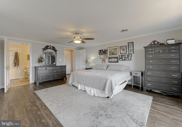 bedroom with ceiling fan, ensuite bathroom, dark wood-type flooring, and ornamental molding