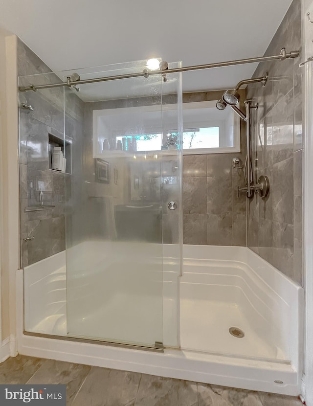 bathroom featuring tile patterned flooring and an enclosed shower