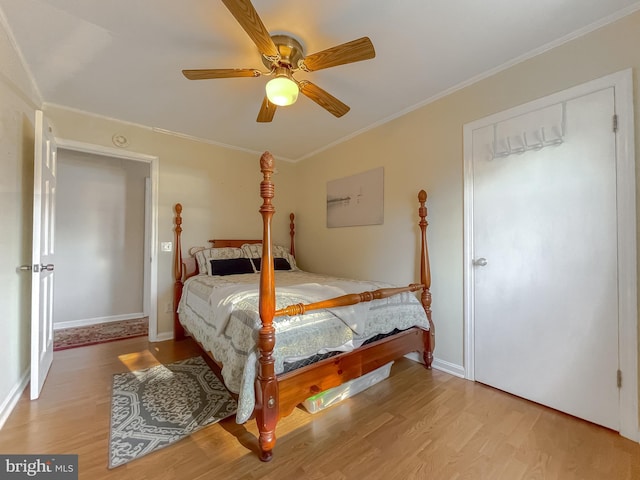 bedroom featuring light wood-type flooring, ceiling fan, and ornamental molding