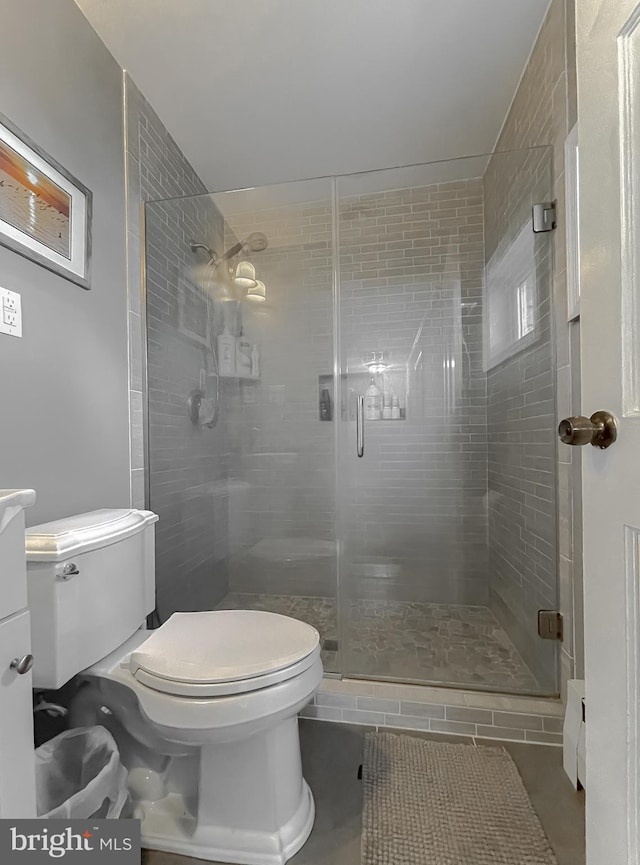 bathroom featuring tile patterned flooring, vanity, toilet, and a shower with door