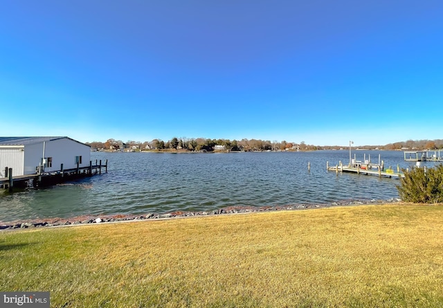 dock area with a yard and a water view