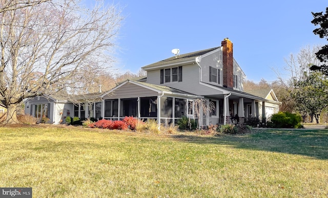 back of house featuring a sunroom, a yard, and a garage