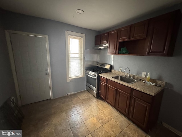 kitchen with gas range, dark brown cabinets, and sink