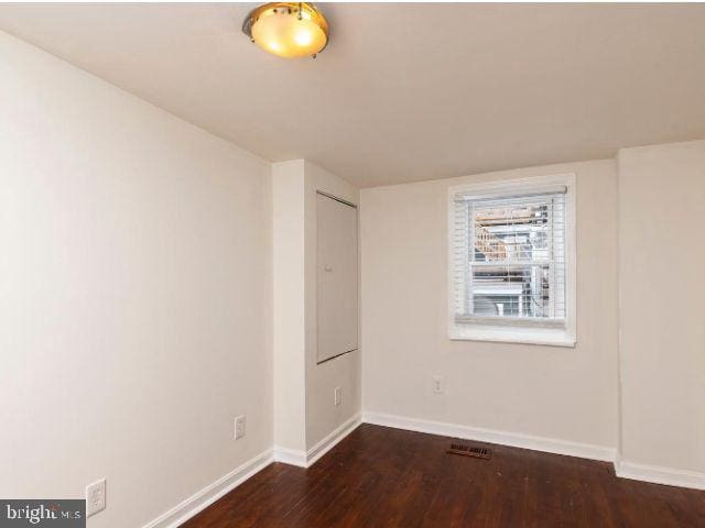 unfurnished room featuring dark hardwood / wood-style flooring