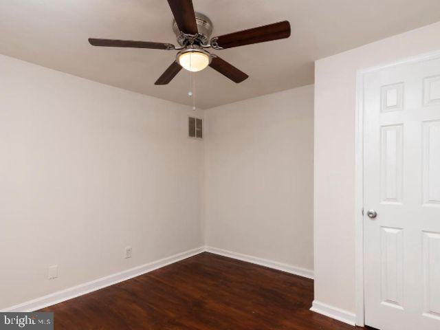 unfurnished room with ceiling fan and dark wood-type flooring