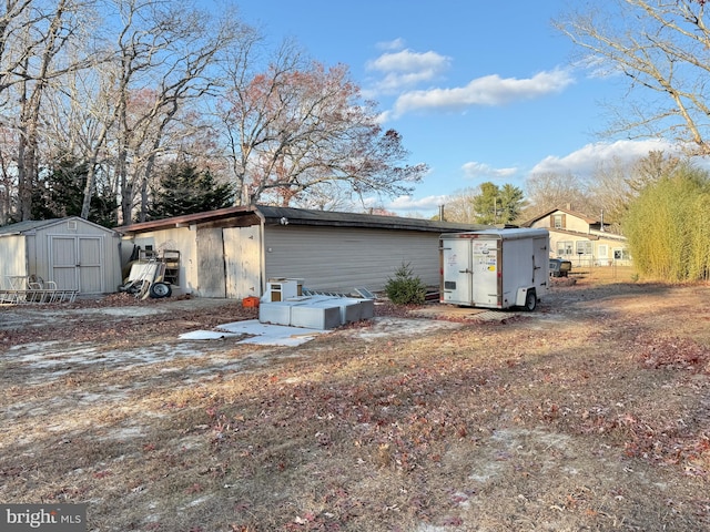 rear view of property featuring a storage unit