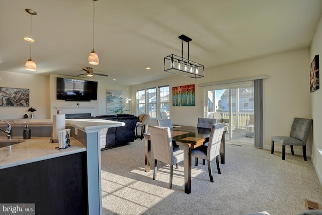 dining area with ceiling fan, light colored carpet, a wealth of natural light, and sink