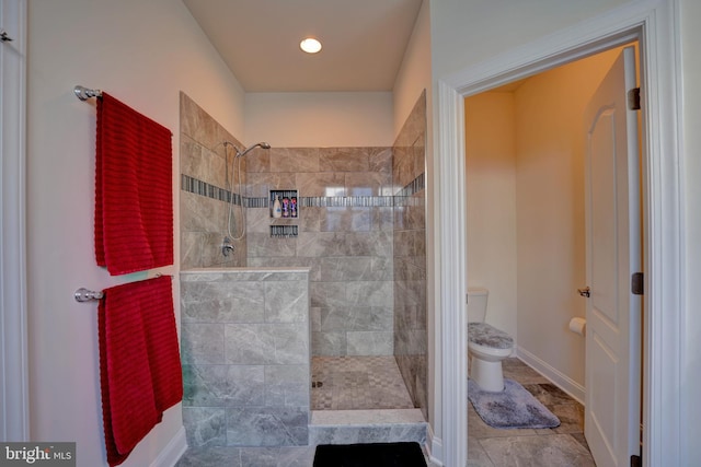 bathroom featuring toilet and tiled shower